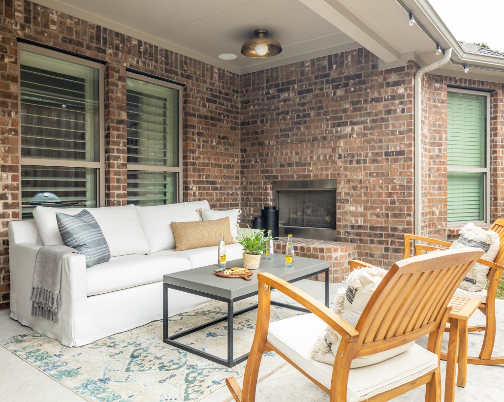 outdoor brick living area with neutral and blue patio furniture