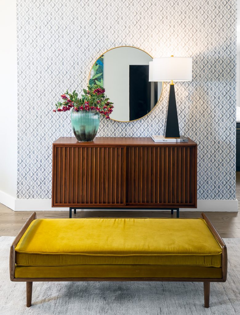 entry way design with yellow seating and patterned wallpaper