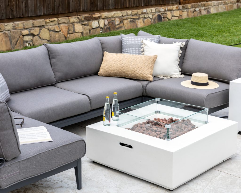 gray patio furniture with neutral fire pit and throw pillows